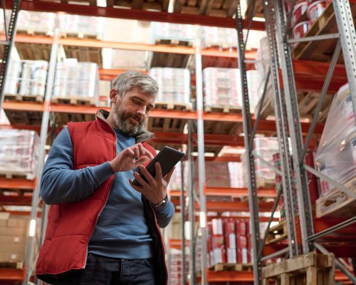 Warehouse worker checking stock with tablet pc