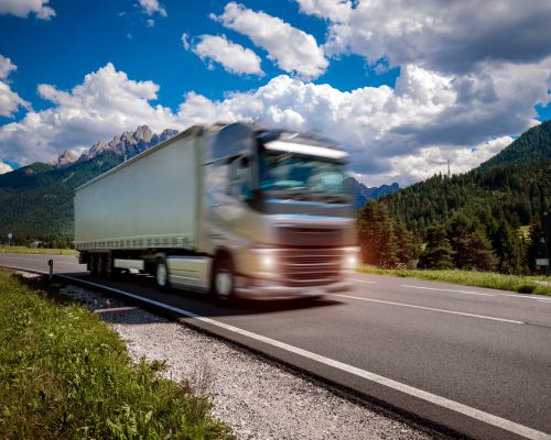 Fuel truck rushes down the highway in the background the Alps. Truck Car in motion blur.