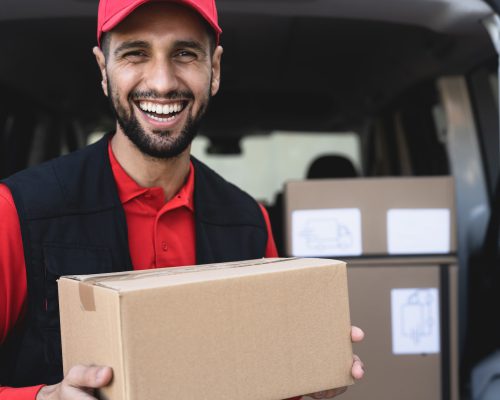 Young delivery man carrying cardboard box - People working with fast deliver transportation